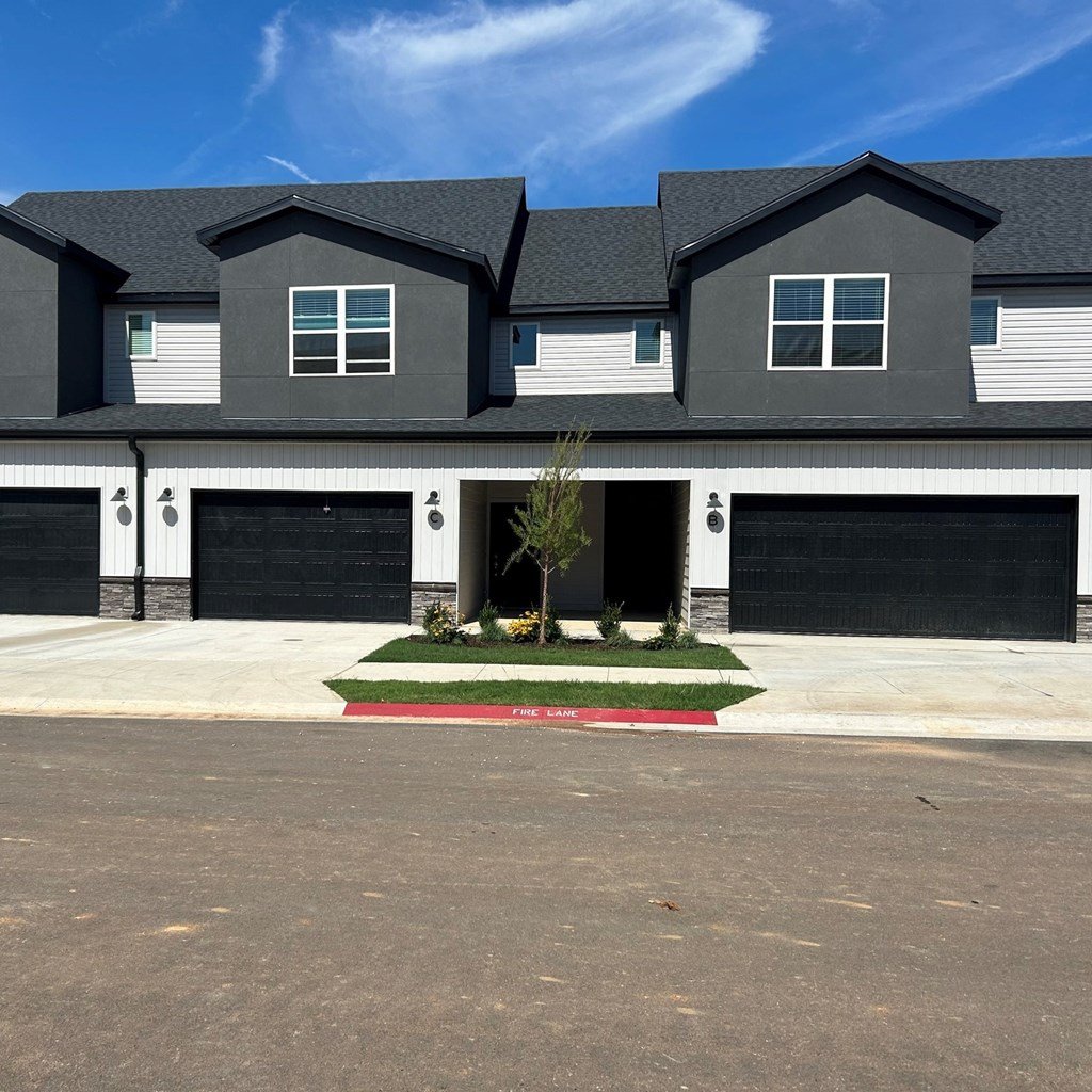 a house with black garage doors and a black roof at Hillcrest Village, Springdale Arkansas