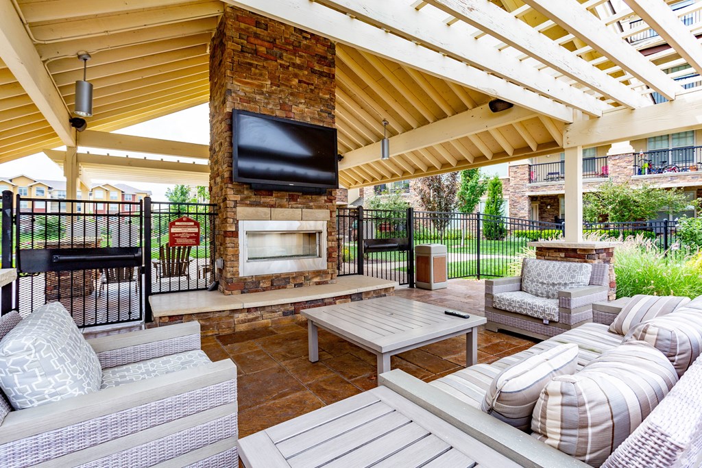 A patio with a fireplace and seating area.