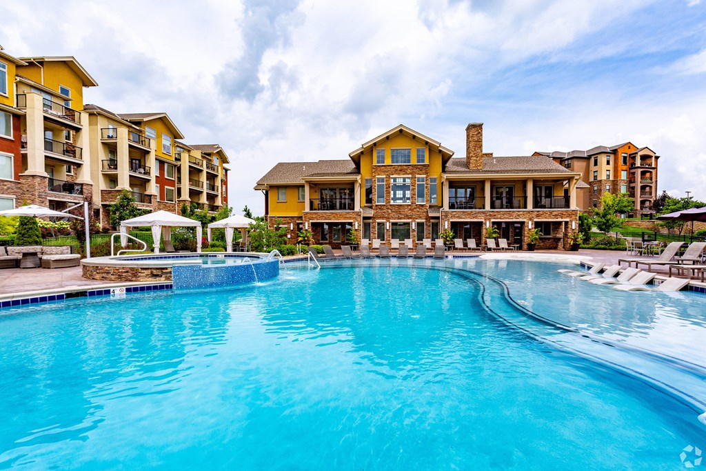 A large swimming pool in front of a resort-style building.