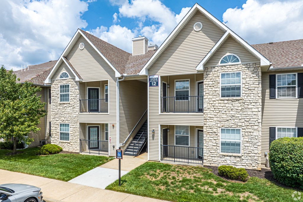 A two-story residential building with a stone facade and a garage door.