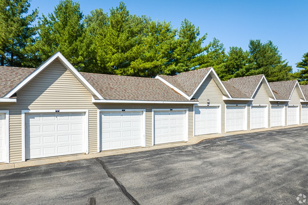 A row of garages with trees in the background.