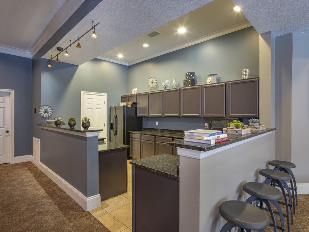 A kitchen with a bar area and stools.