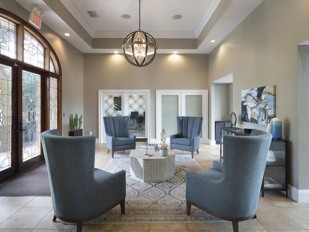 A living room with grey chairs and a round table.