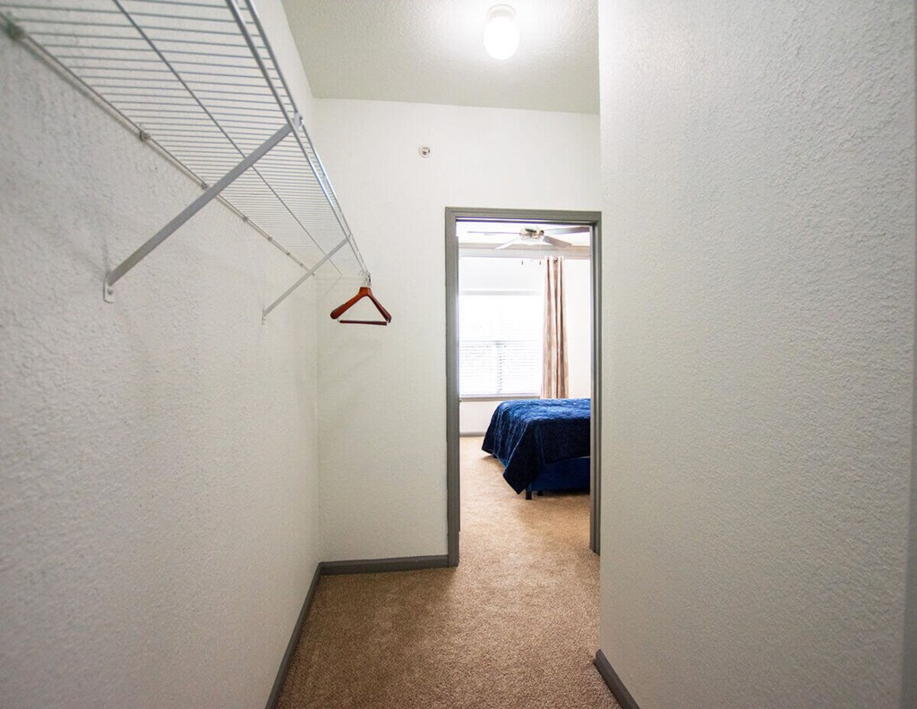 A room with a bed and a hanger on the wall.