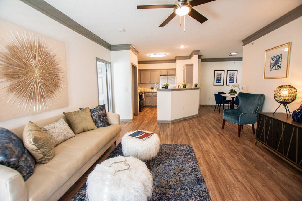A living room with a white couch and a blue chair.