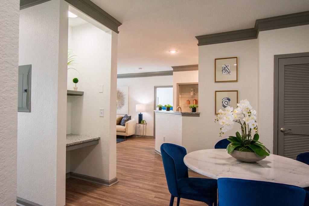 A dining room with a round table and blue chairs.