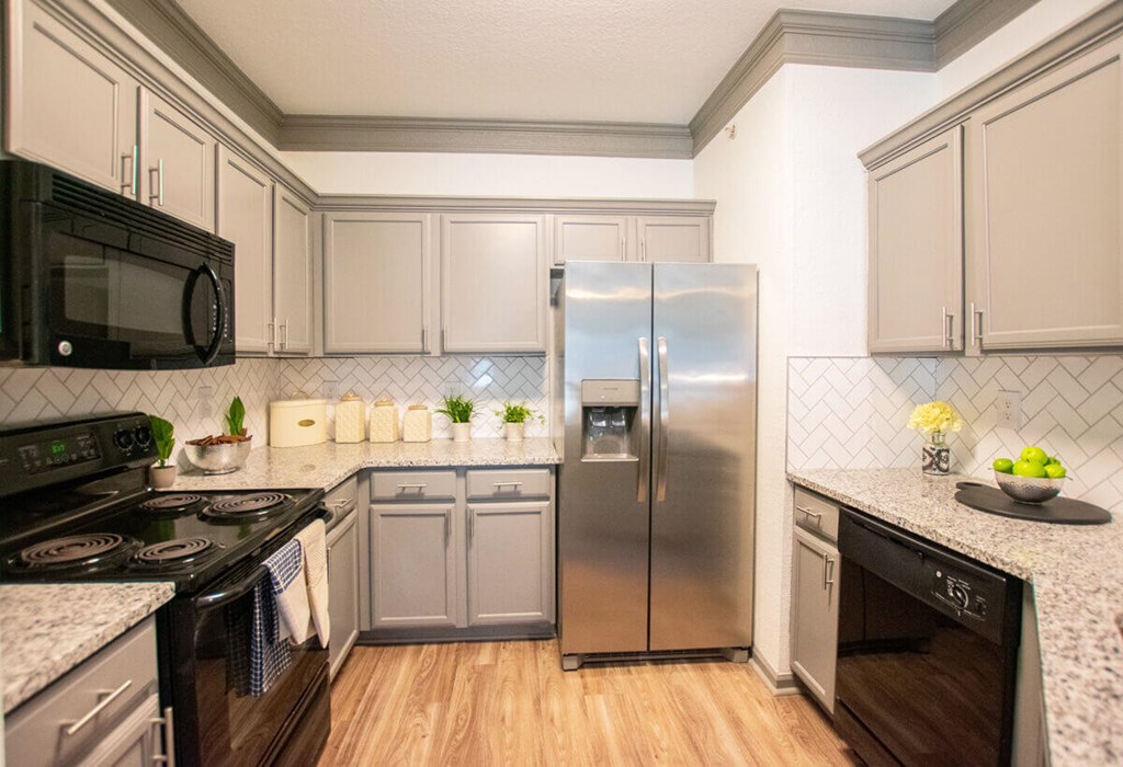 A kitchen with a stove, refrigerator, and oven.