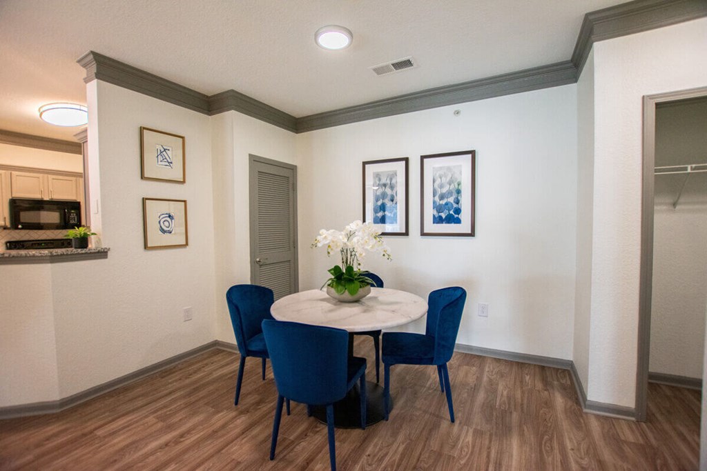 A dining room with a table and chairs.