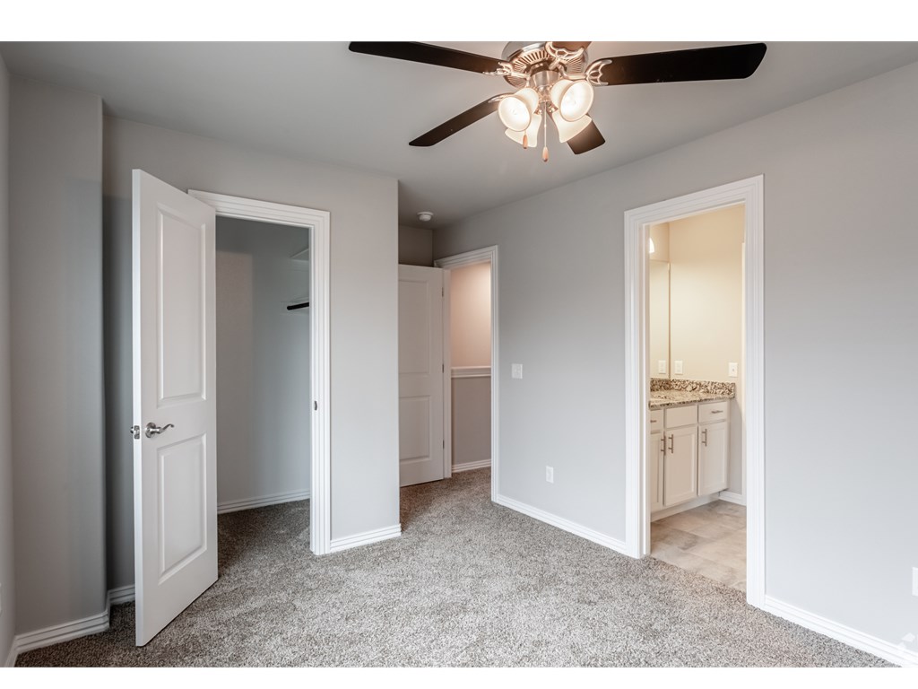 a bedroom with a ceiling fan