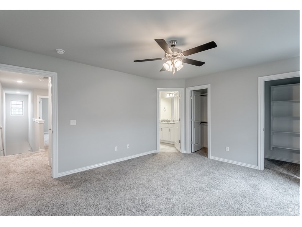a bedroom with gray walls and a ceiling fan