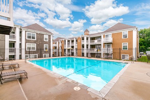 A large swimming pool in front of apartment buildings.