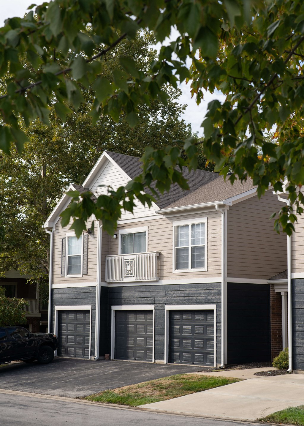 a house with three garage doors on a street at Centennial Park Apartments, Overland Park, Kansas