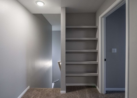a walk in closet with empty shelves and a door at Centennial Park Apartments, Overland Park, Kansas