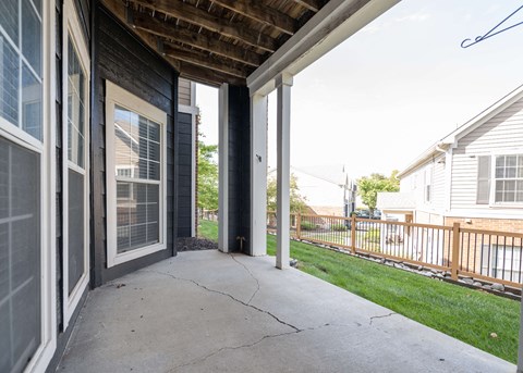 the front porch of a home with a concrete sidewalk and a wooden roof at Centennial Park Apartments, Overland Park, Kansas