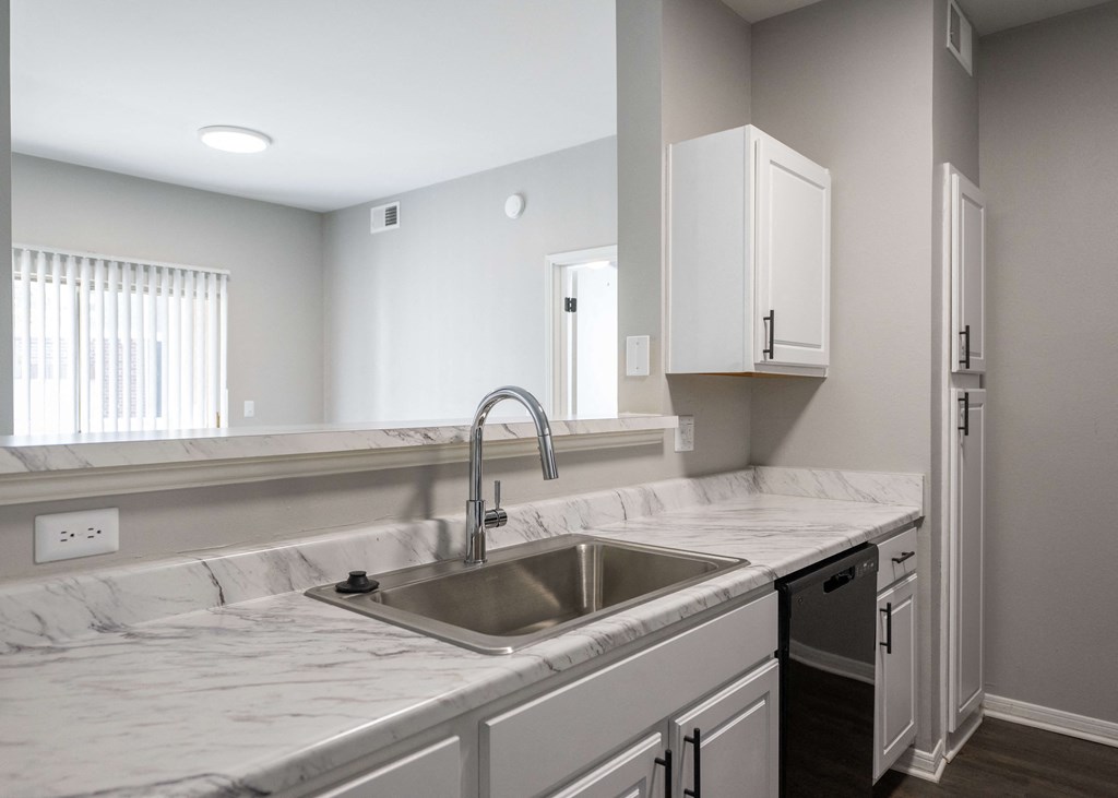 a kitchen with white marble counter tops and a sink a kitchen with white marble counter tops and a sink at Centennial Park Apartments, Overland Park, Kansas