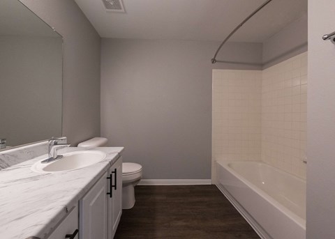 an empty bathroom with a sink and a bath tub at Centennial Park Apartments, Overland Park, 66213
