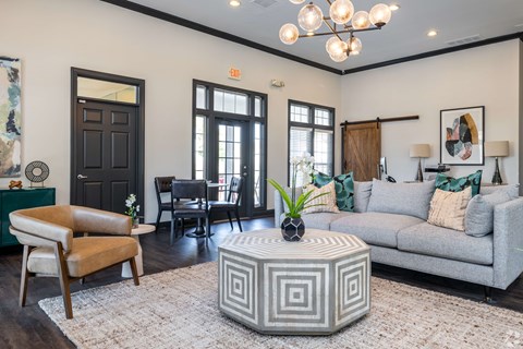 A living room with a grey sofa, a wooden coffee table, and a chandelier.