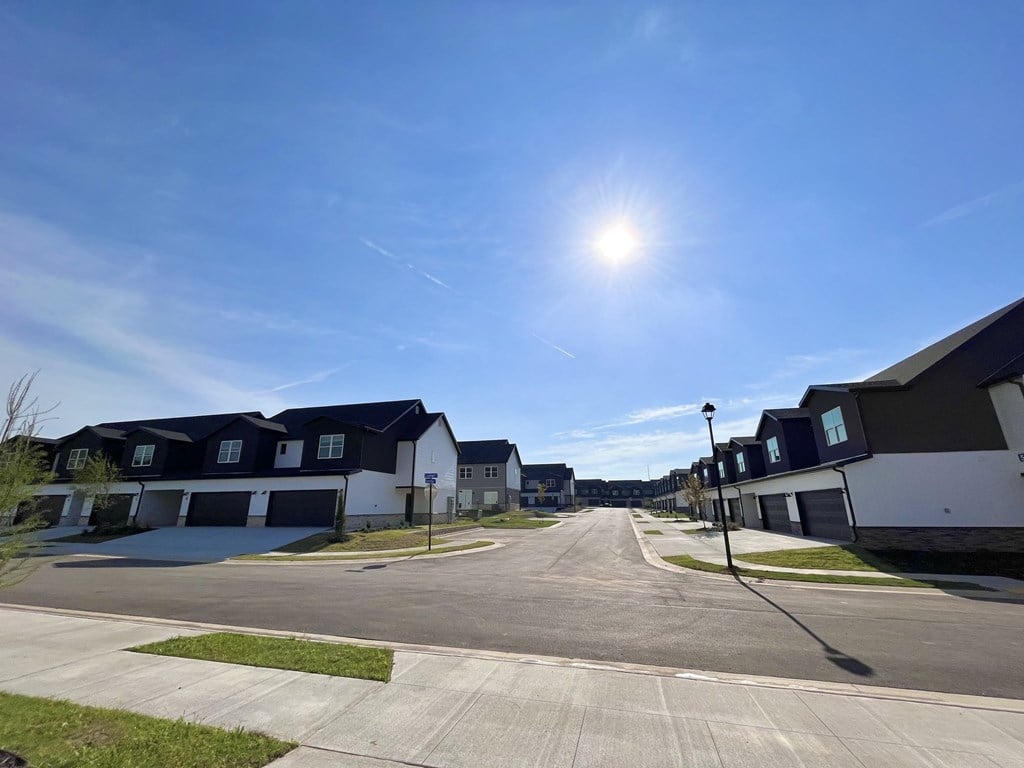 a street of houses with the sun shining in the blue sky at Hillcrest Village, Springdale