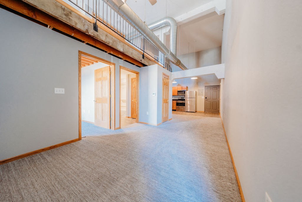 a renovated living room with a hallway to a bedroom and a kitchen