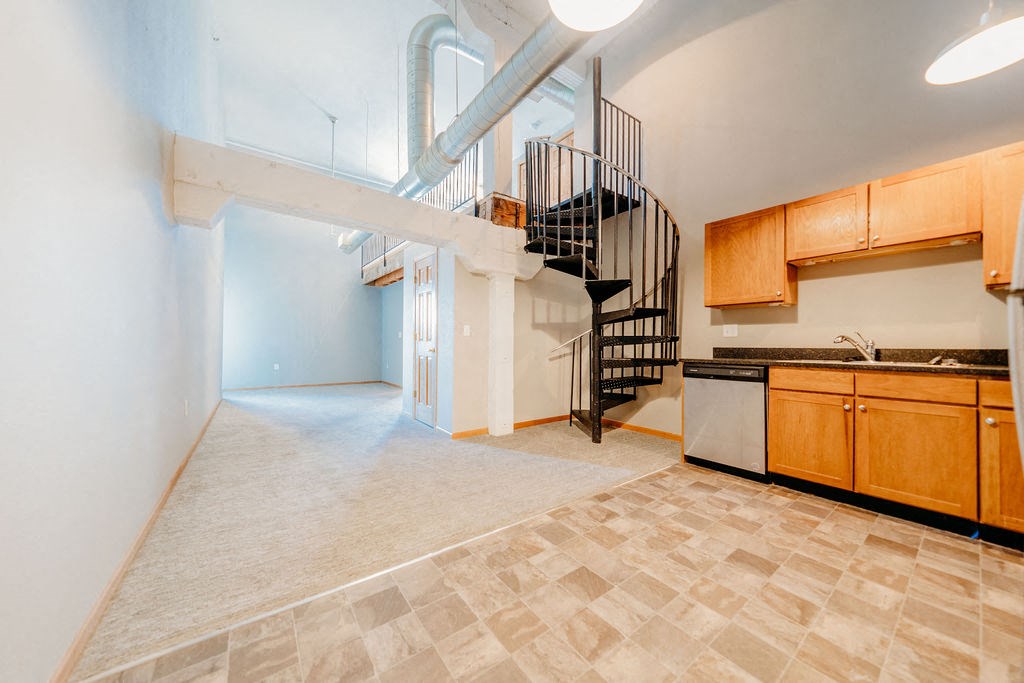 a kitchen with a spiral staircase in the middle of a room