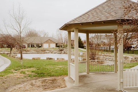 a gazebo with a pond in the background