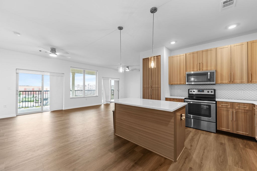 A kitchen with wooden cabinets and a stainless steel oven.