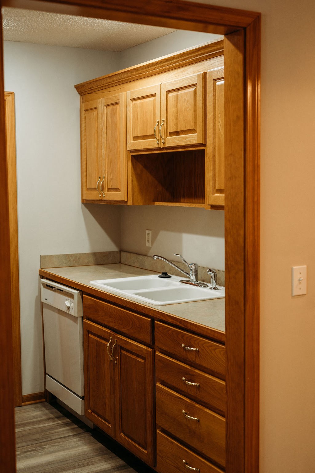 a kitchen with wooden cabinets and a white dishwasher