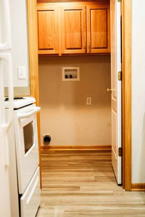 a kitchen with white appliances and wooden cabinets