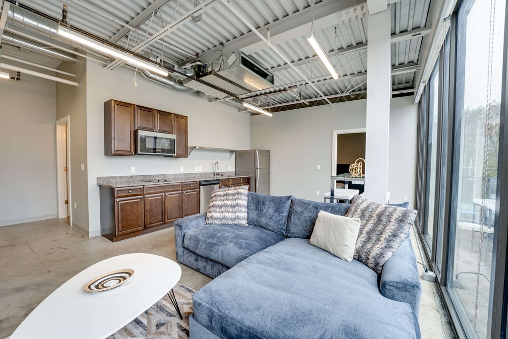 a living room with a blue couch and a kitchen