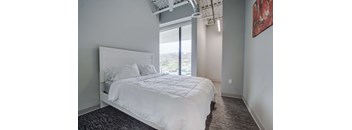 a bedroom with a large white bed and a window