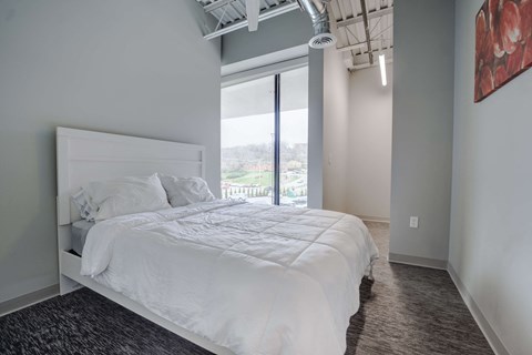 a bedroom with a large white bed and a window