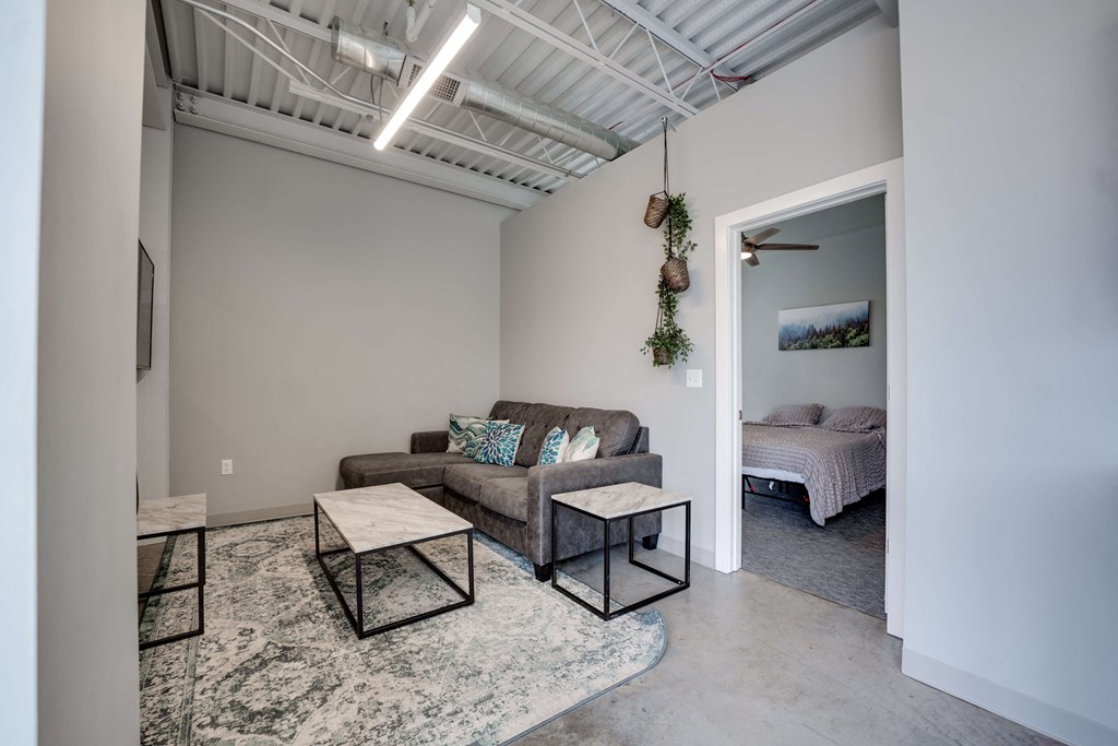 a living room with a couch and a table     and a bedroom
