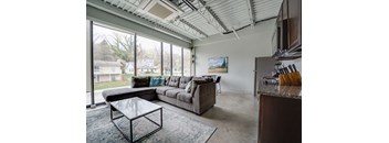 a living room with a couch and a coffee table and large windows