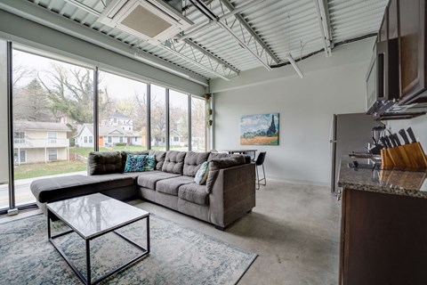 a living room with a couch and a coffee table and large windows