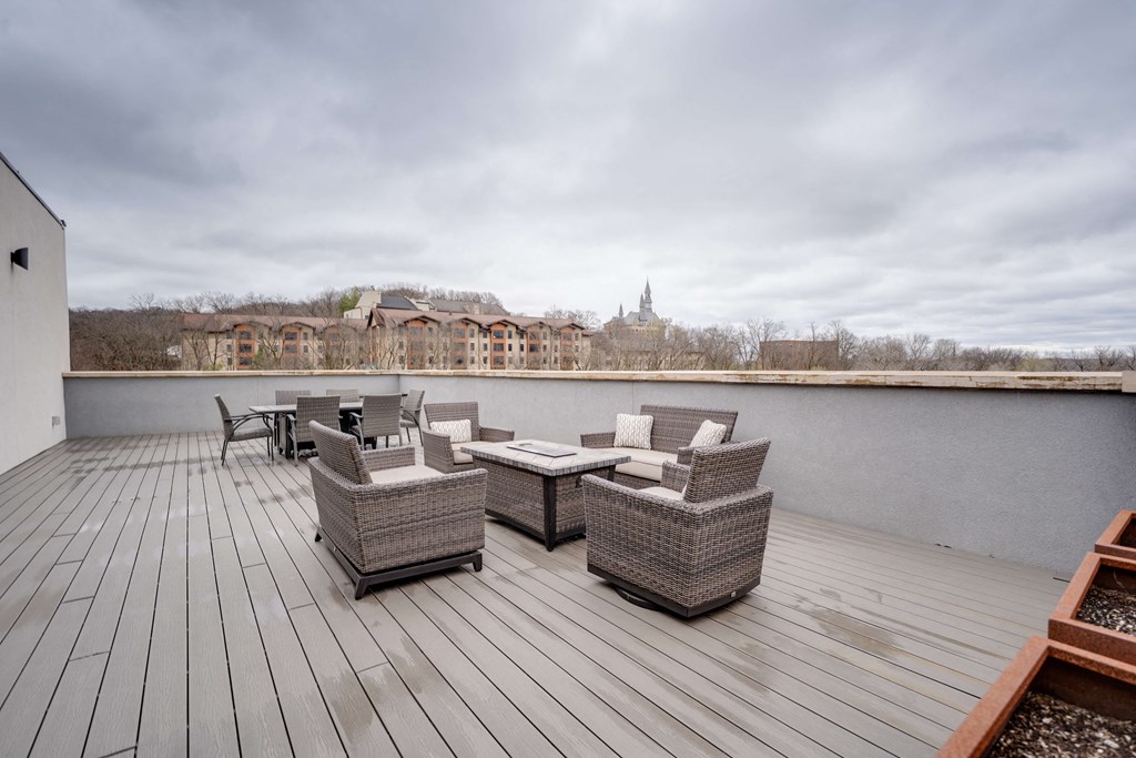 the deck has a view of the river and a patio with chairs and tables