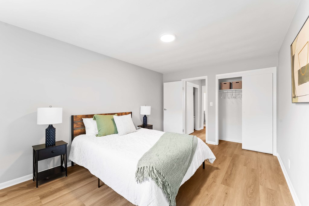 A bedroom with a bed, nightstand, and lamp.