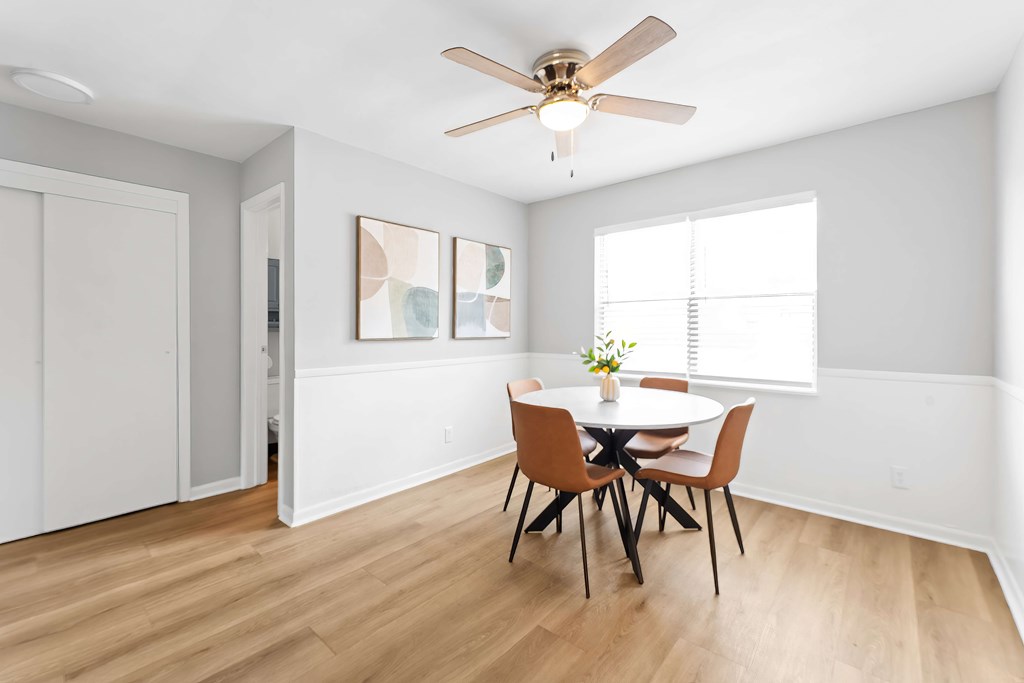 A dining room with a table and chairs.