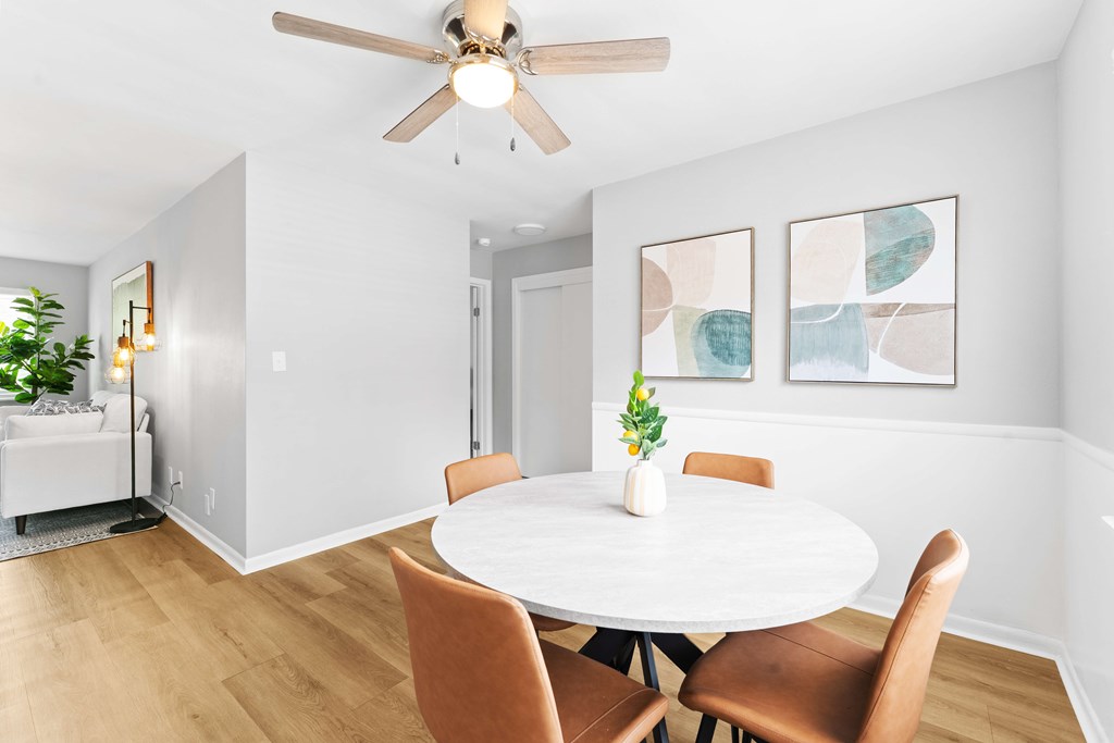 A dining room with a white table and chairs.