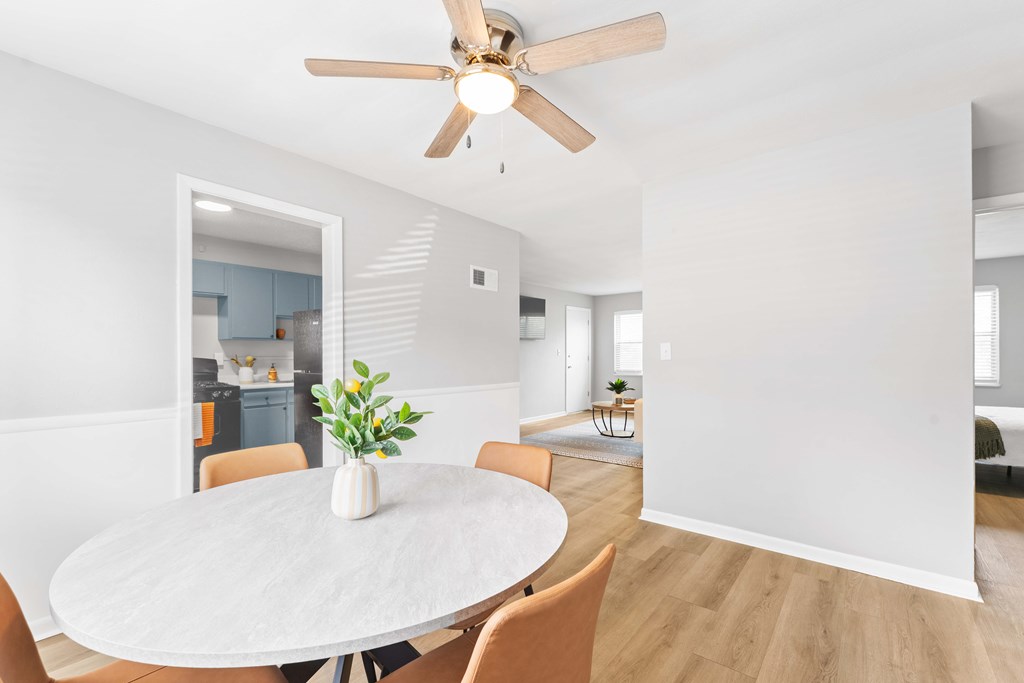 A dining room with a white table and chairs.