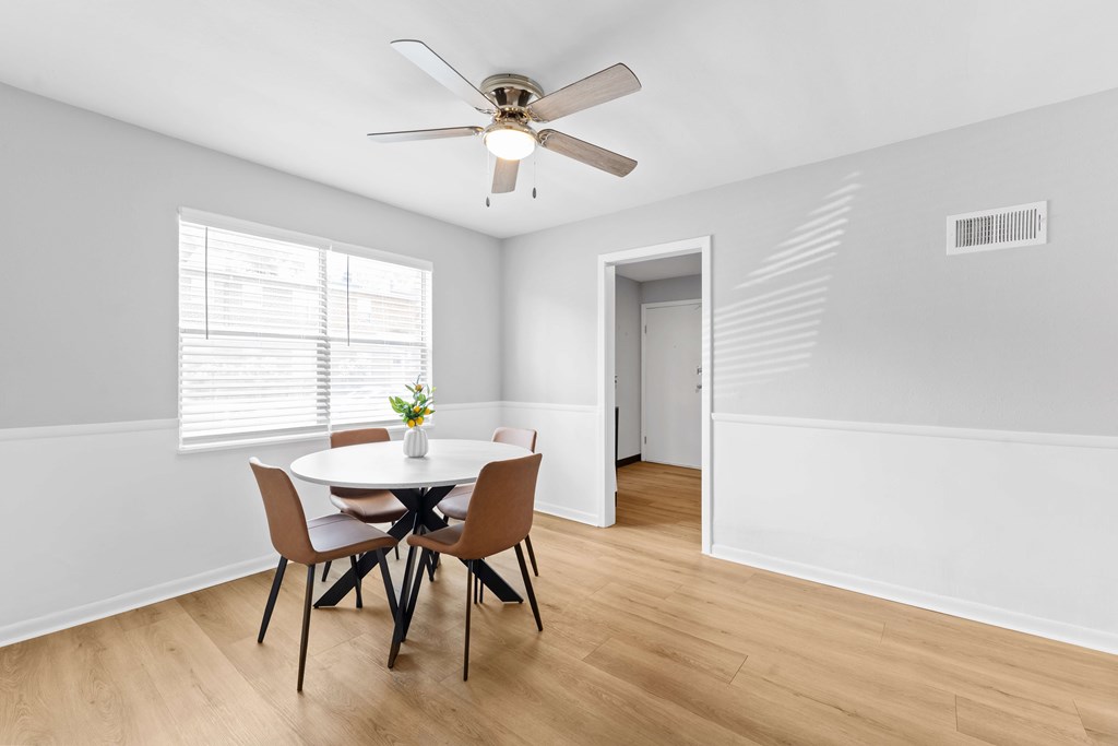 A dining room with a table and chairs.