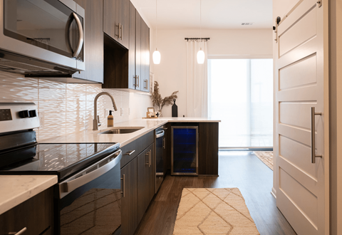 a kitchen with black and white counter at tops and a sink, at The View at Castle Rock, CO, 80104