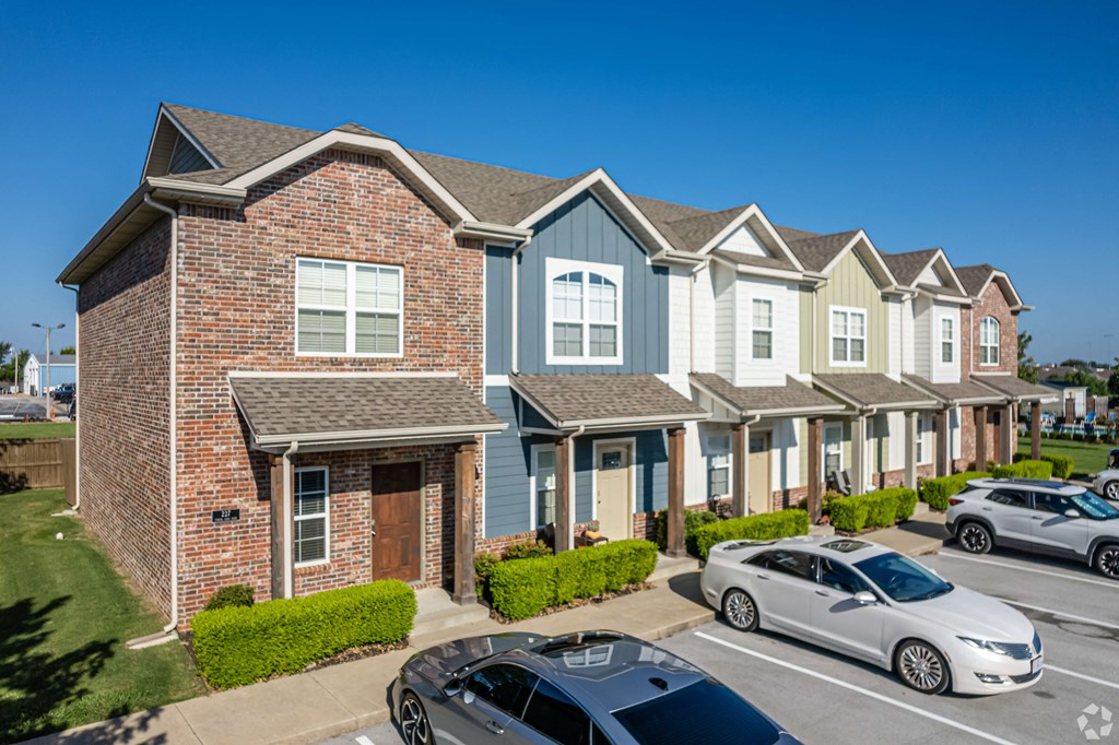 a row of houses with cars parked in front of them