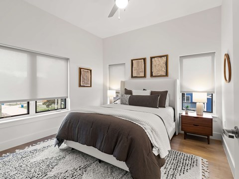 A bedroom with a large bed and a ceiling fan.