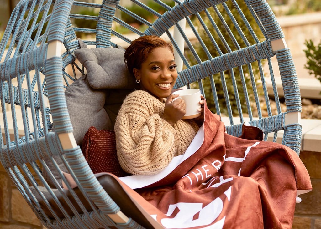 Girl sitting in egg chair with coffee mug at The Residences at Galleria, Kansas