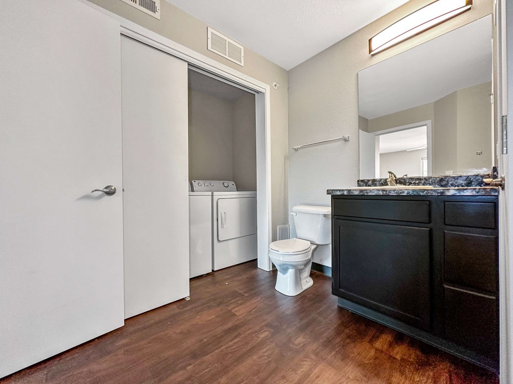A bathroom with a toilet, sink, and a cabinet.