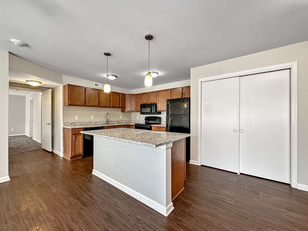 A kitchen with a white island and wooden cabinets.