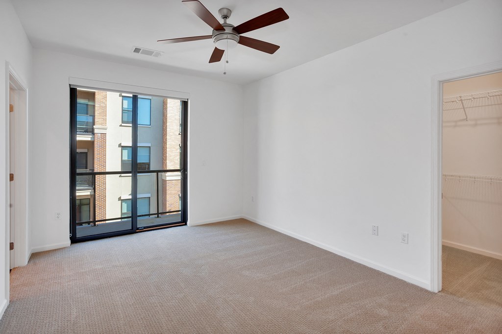 Empty bedroom with large windows and ceiling fan at 44 Washington, Kansas City, Missouri