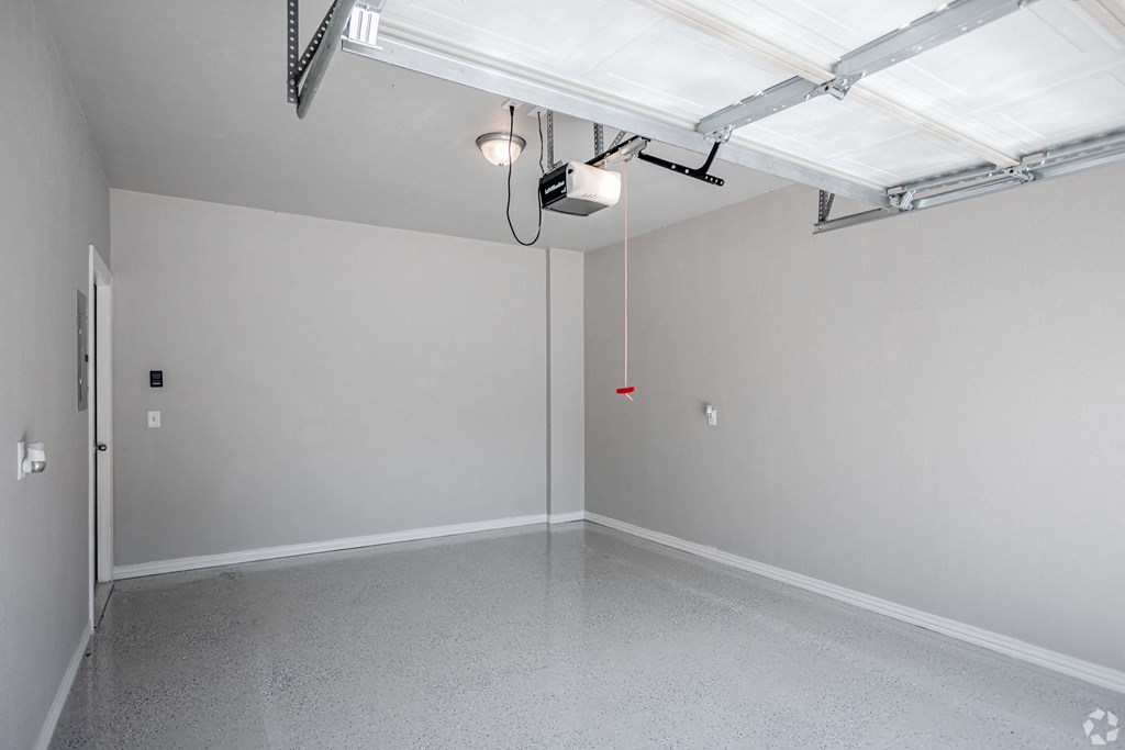the interior of a garage with white walls and a concrete floor