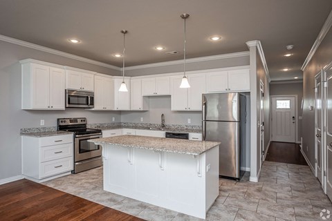 a kitchen with white cabinets and stainless steel appliances