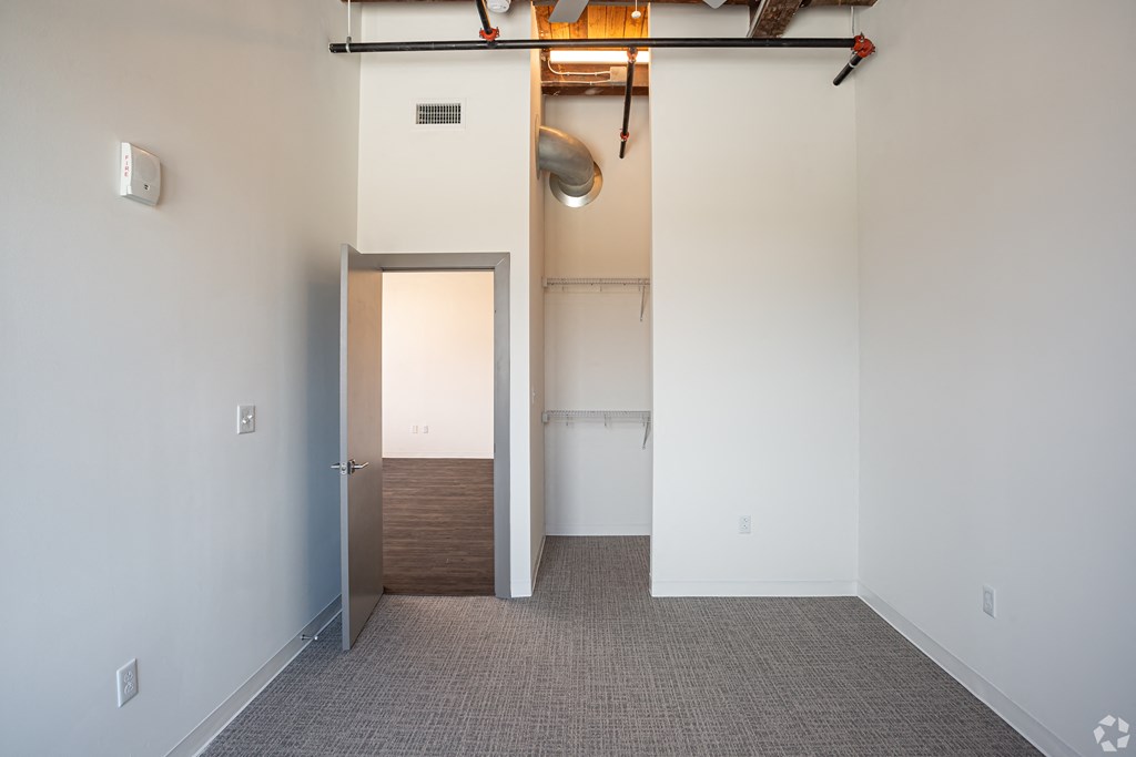an empty room with white walls and a door to a closet